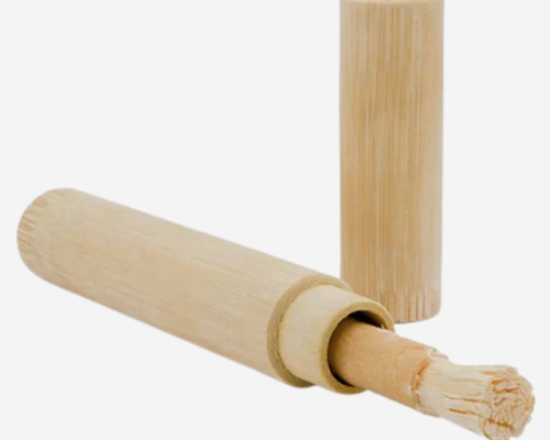 Bamboo Peelo Miswak holder with a Peelo Miswak stick partially inserted, showing the natural bamboo storage case and removable cap